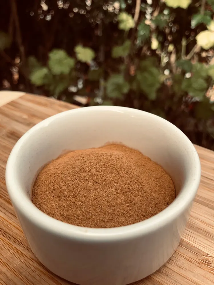 A bowl of ground Ceylon cinnamon on a wooden board at the estate